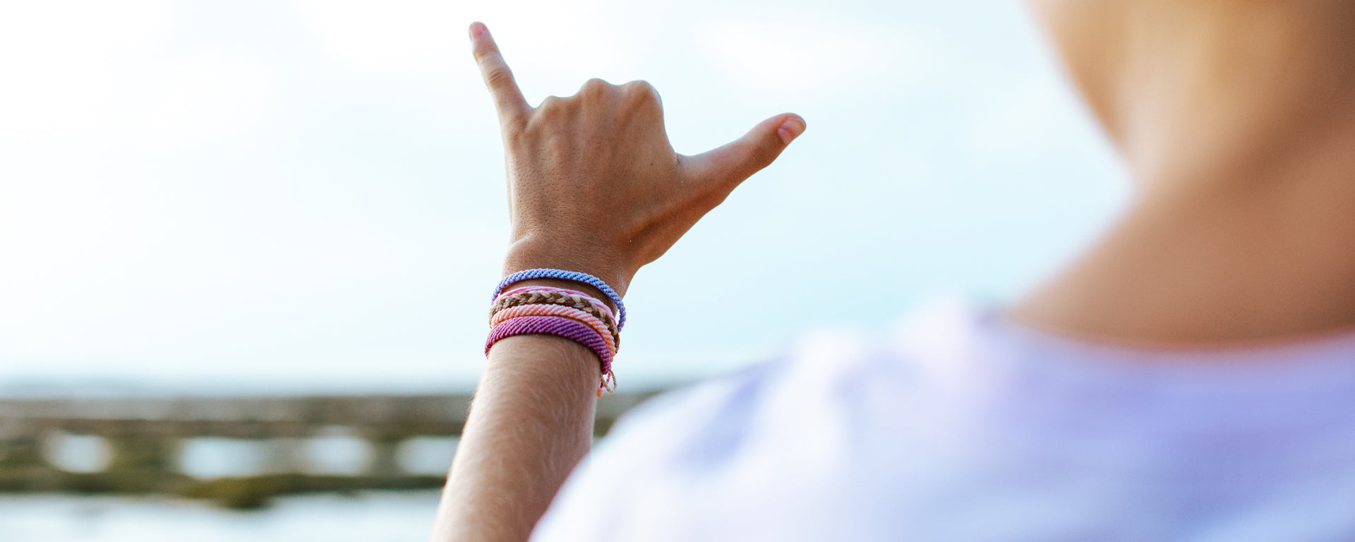 Waxed waterproof bracelet on hand making shaka sign on beach