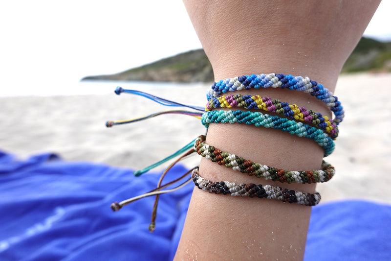 Braided multi color water proof bracelets on hand by beach